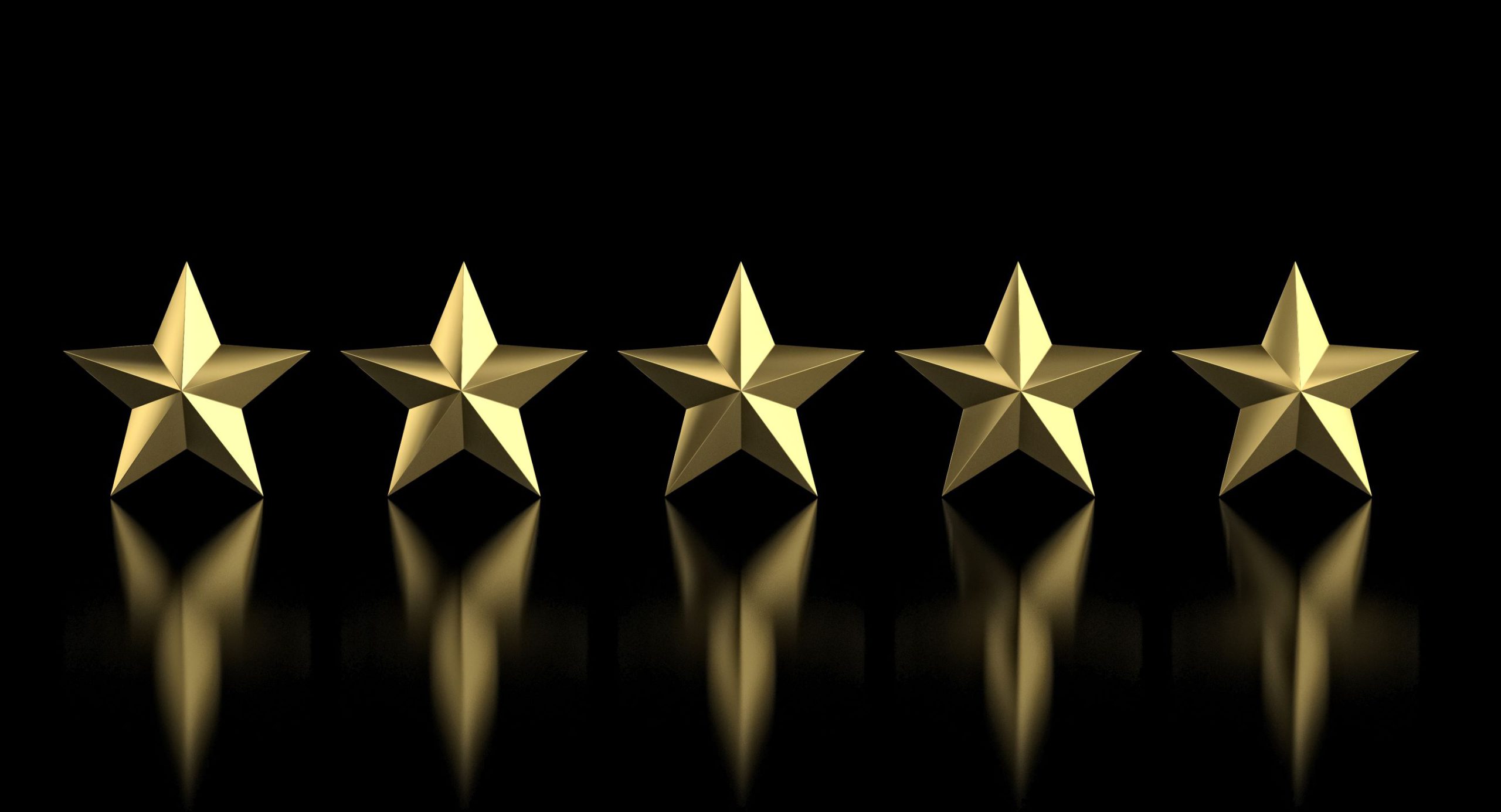 five metal stars showing a reflection on a black background